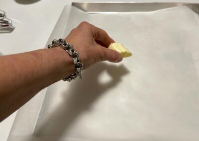 In una leccarda di 25X30 cm con carta forno passa un pezzetto di burro  freddo sulla carta forno (servirà per staccare bene la pasta biscotto)