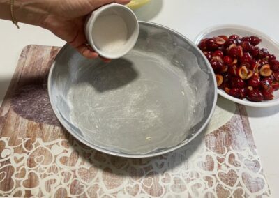 Versate nello stampo imburrato e infarinato i due cucchiai di zucchero semolato