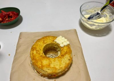 Bagnate con lo sciroppo leggermente la superficie della torta, poi copritela con ciuffetti di crema diplomatica
